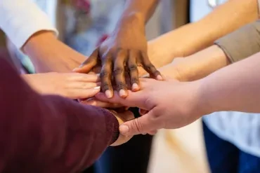 Diverse group of hands joined together representing community and teamwork