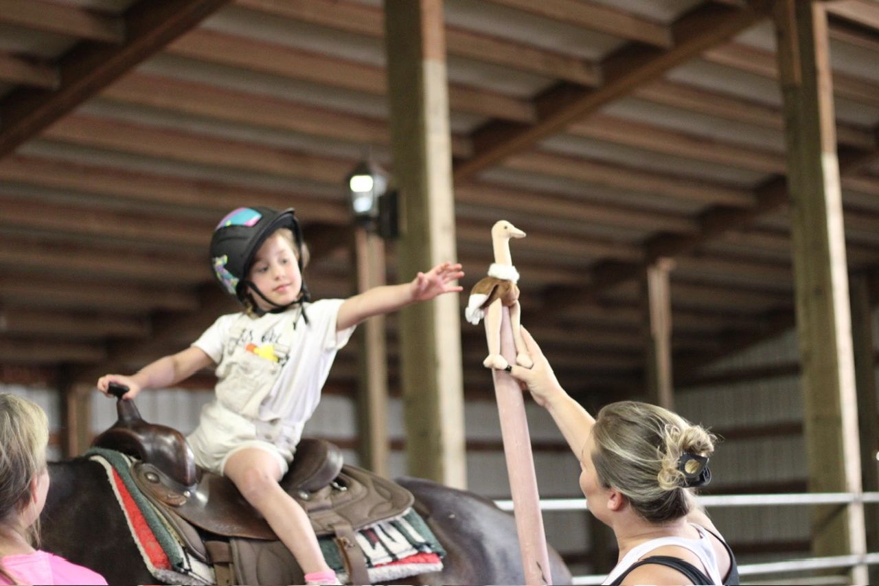 Young child on horseback during a riding lesson